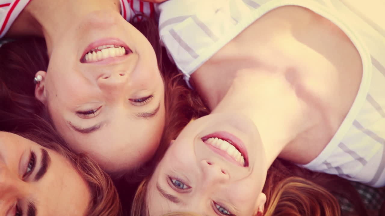 amigos felices en un parque acurrucado en círculo