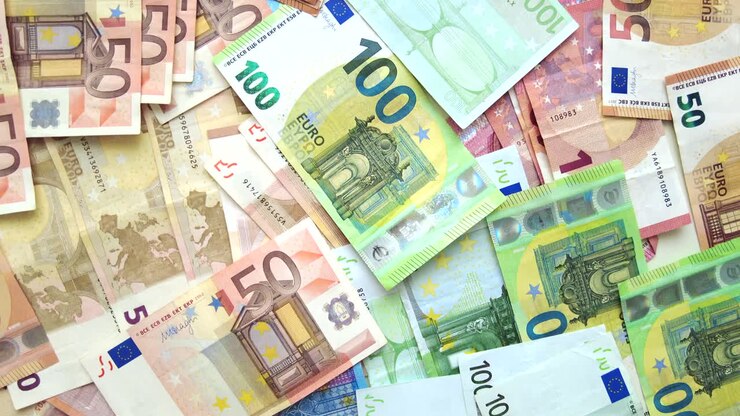 Nahaufnahme von mehreren Fünfzig- und Hundert-Euro-Scheinen, die auf einer Oberfläche verstreut sind