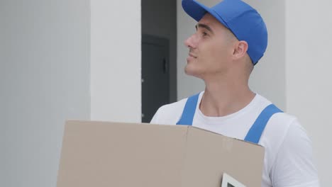 young courier holding a parcel and tablet walking on the street to deliver a box directly to a customer home.