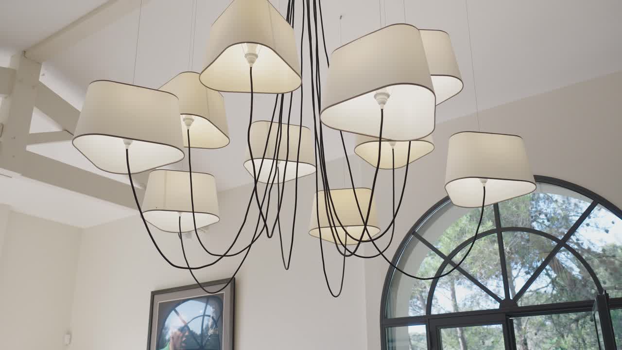빌라에 매달려 있는 추상적인 천장 조명을 중심으로 느리게 회전하는  ⁇