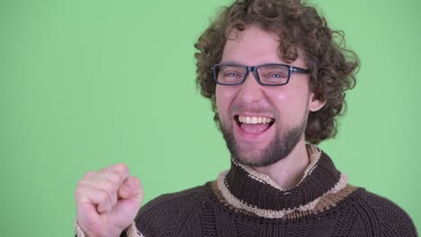 un joven guapo con barba y cabello rizado.