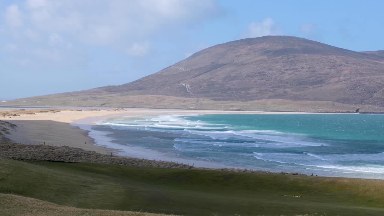 vista del paisaje de la idílica playa de arena blanca con océano azul y terreno montañoso en la remota isla de lewis y harris, hébridas exteriores, escocia occidental, reino unido