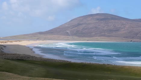 Vista-Panorámica-De-Una-Idílica-Playa-De-Arena-Blanca-Con-Océano-Azul-Y-Terreno-Montañoso-En-La-Remota-Isla-De-Lewis-Y-Harris,-Hébridas-Exteriores,-Escocia-Occidental,-Reino-Unido