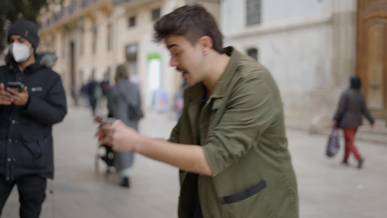 Mago che esegue trucchi con le carte in una strada cittadina