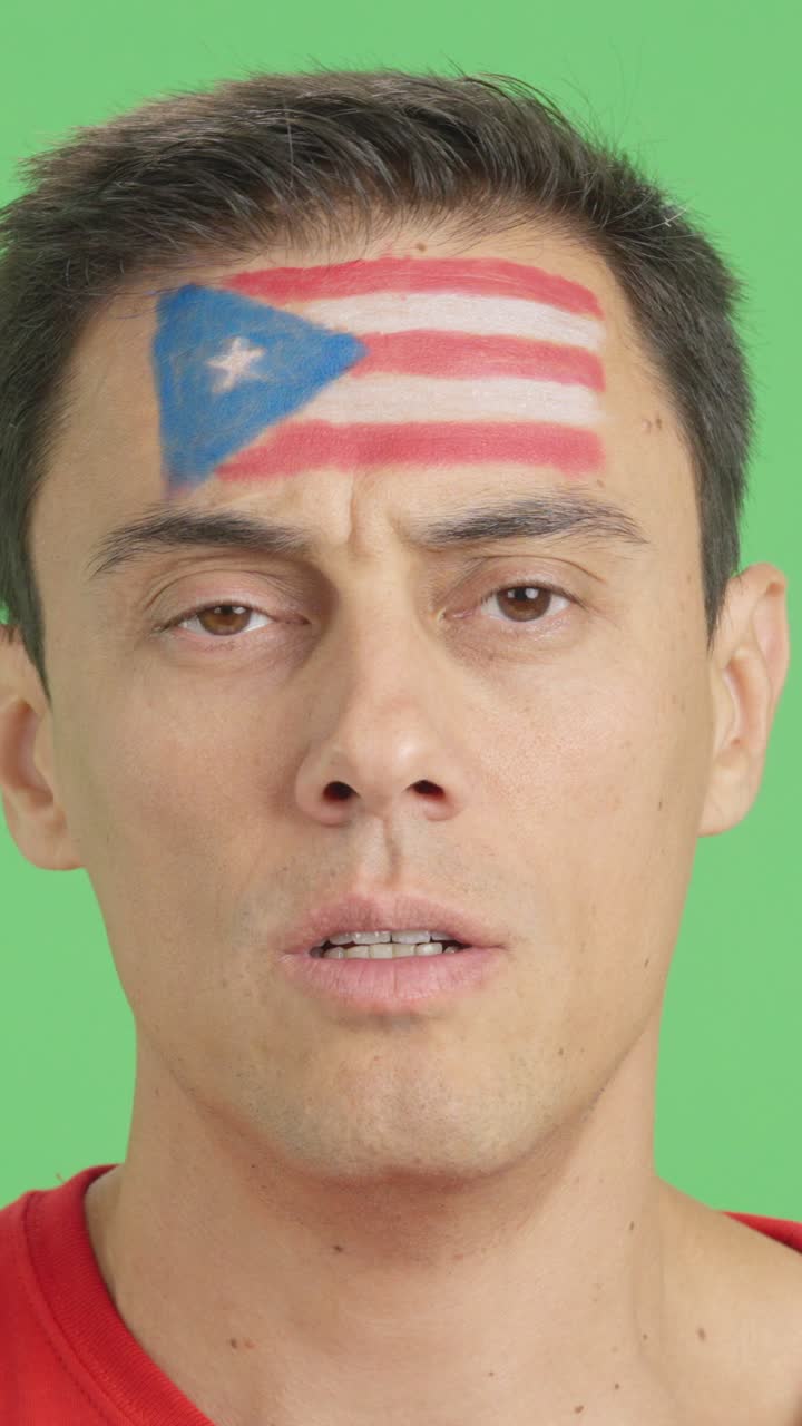 Man with a puerto rican flag painted on the face smiling