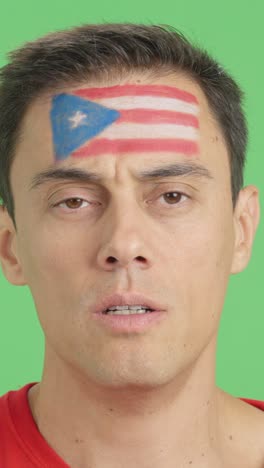 man with a puerto rican flag painted on the face smiling