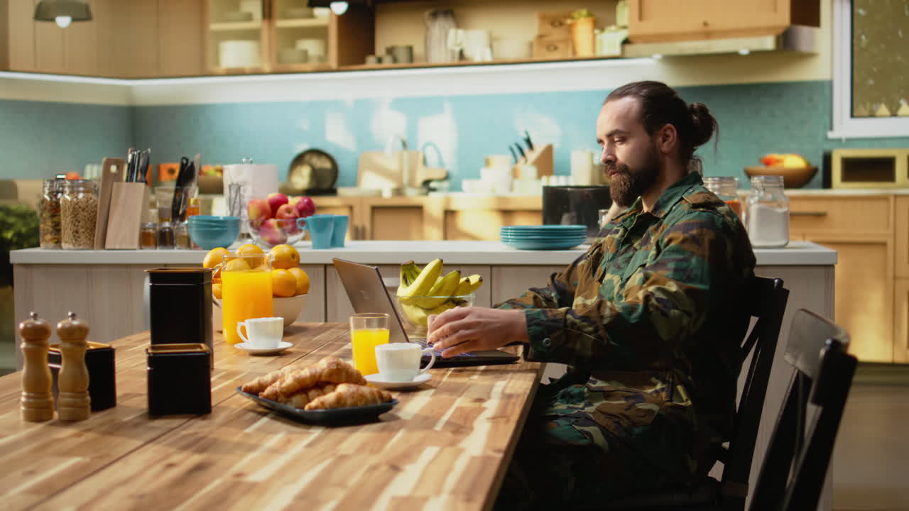 Serviceman in army uniform, breakfast at home, serving coffee and pastry