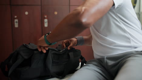 a person packing a sports bag in a locker room