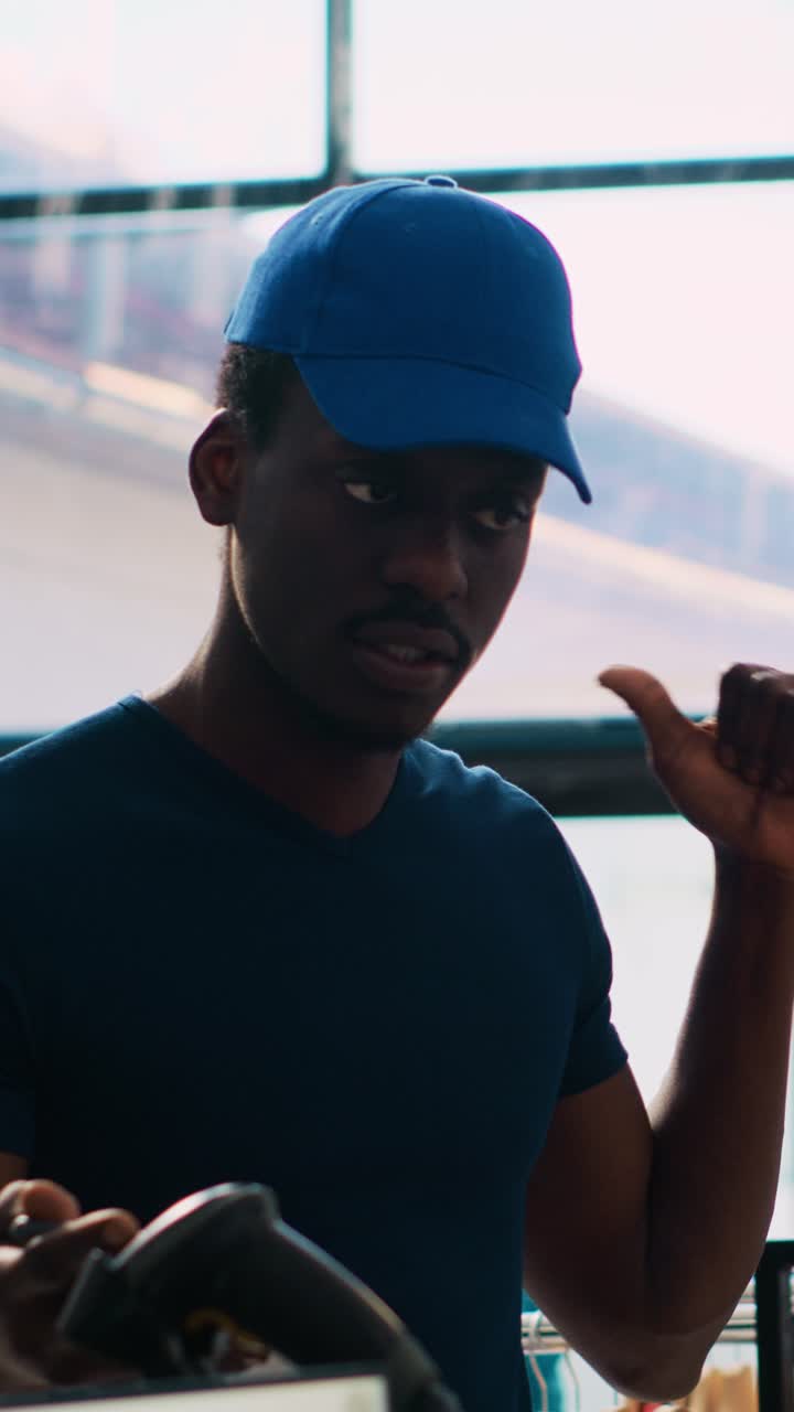 Man in baseball cap using barcode scanner