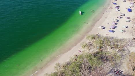 conchal beach shore costa rica with blue ocean and tourists on sandy shore, 4k aerial drone