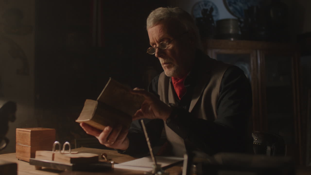 Old passionate man read a book in his office at night