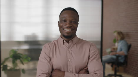 portrait of young african american businessman smiling arms crossed enjoying successful start up business confident entrepreneur in modern office workspace