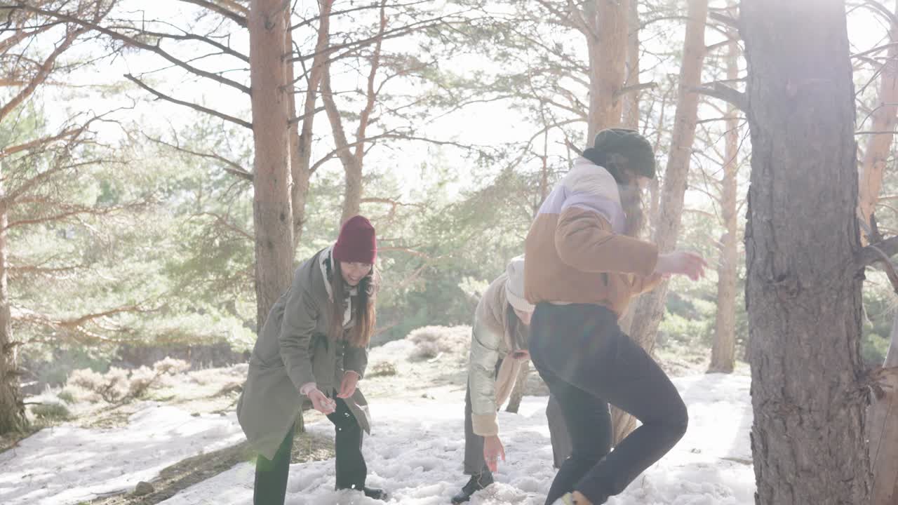 Women having a snowball fight in the forest in winter