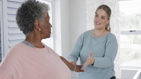 caucasian nurse with senior woman exercising, copy space, slow motion