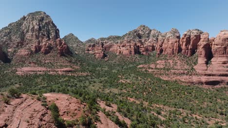 stunning red rock formations and green valley in sedona, arizona under clear skies , aerial view