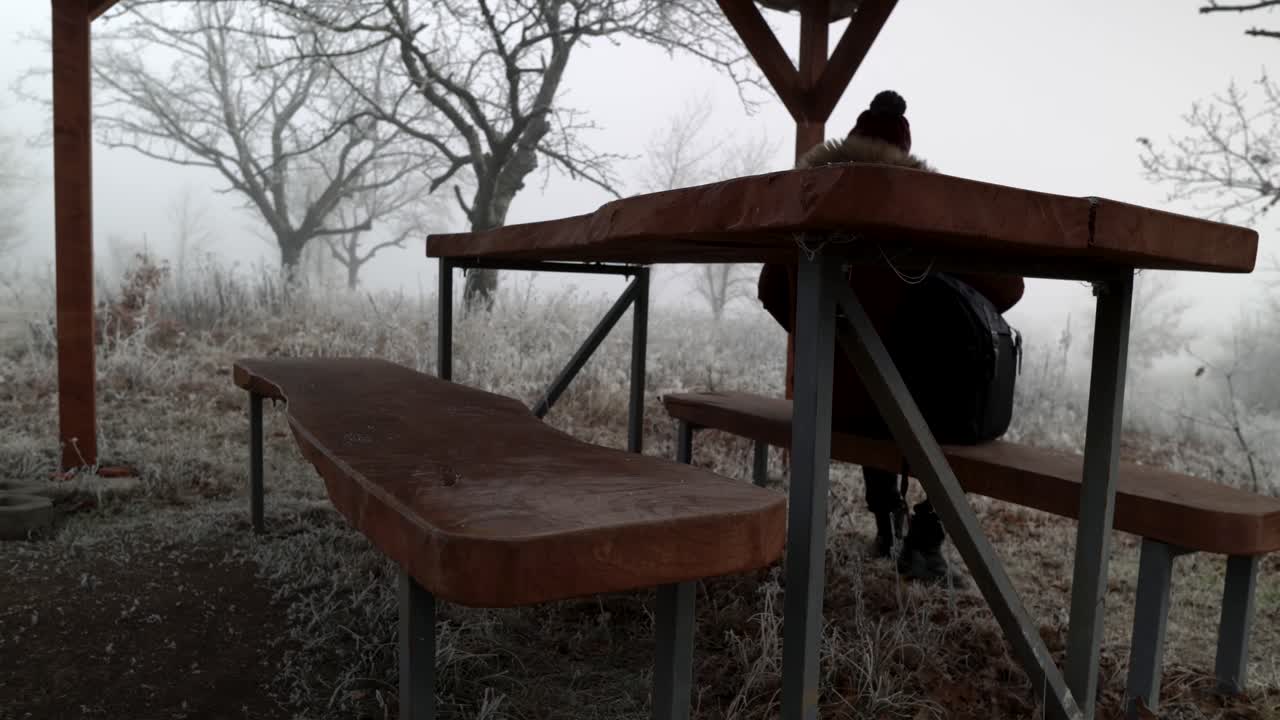 배낭을 벤치에 놓고 신비로운 흐릿한 숲에서 쉬고 있는 등산객