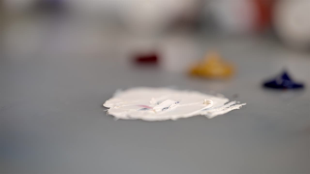 profundidad poco profunda del campo del cuchillo de paleta extendiendo y mezclando pintura al aceite