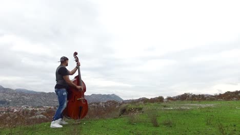 man playing double bass in nature