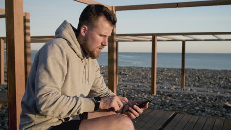 man using phone on a beach