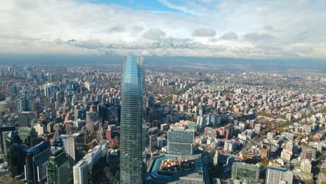 Panoramic-drone-shot-of-the-Providencia-skyline,-snowy-Andes-in-background-in-Chile