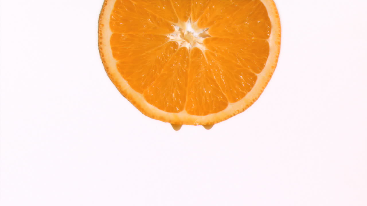 Dråbe appelsinjuice falder i super slowmotion