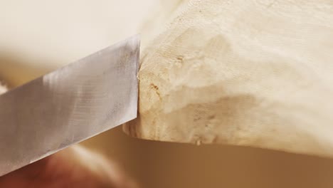 Close-shot-of-a-chisel-on-a-wooden-table