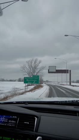 video of a snowy road from a car's dashboard perspective, capturing a wintry landscape with overcast