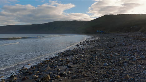 Niedriger-Drohnenschuss-über-Dem-Kiesstrand-Von-Runswick-Bay-Mit-Blick-Auf-Die-Küste