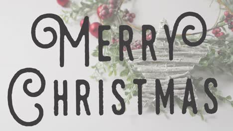 Animation-of-merry-christmas-text-banner-against-christmas-decorations-on-white-surface