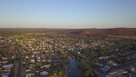 aerial: drone flying over the town of stanthorpe in queensland during golden hour sunrise