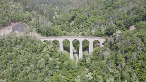 stone train viaduct crossing a mountain pass forests in czechia,zoom