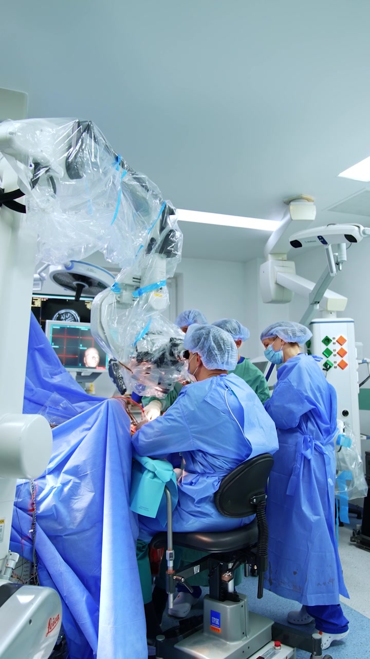 Medicinsk team udfører neurokirurgisk operation ved hjælp af mikroskop. Moderne hjerneoperation. Lodret video