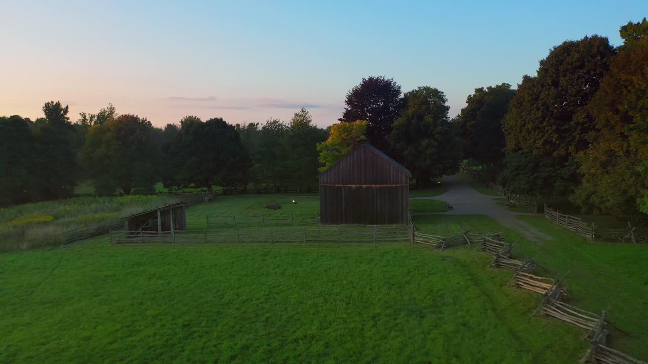 drone aerial backs away from a barn to a field near the Joseph Smith family farm, frame house, temple, visitors center, sacred grove in Palmyra New York Origin locations for the book of Mormon