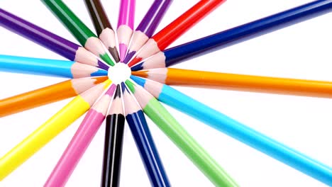los lápices multicolores de los niños giran sobre un fondo blanco.