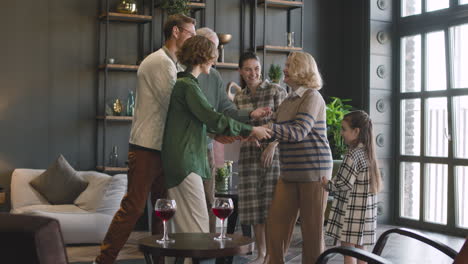 happy family visiting grandparents at home and embracing together