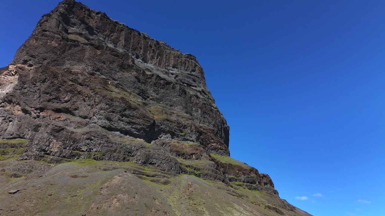 Vista aerea del monte Lómagnúpur vicino al ghiacciaio Vatnajökull, nell'Islanda meridionale, che mostra scogliere spettacolari, fiumi intrecciati e vaste pianure vulcaniche sotto un cielo azzurro.