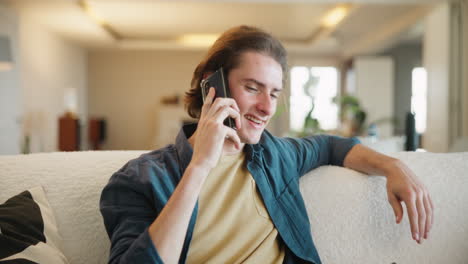 hombre hablando por teléfono en el sofá