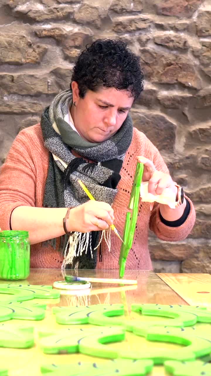 Woman painting wooden cactus decorations