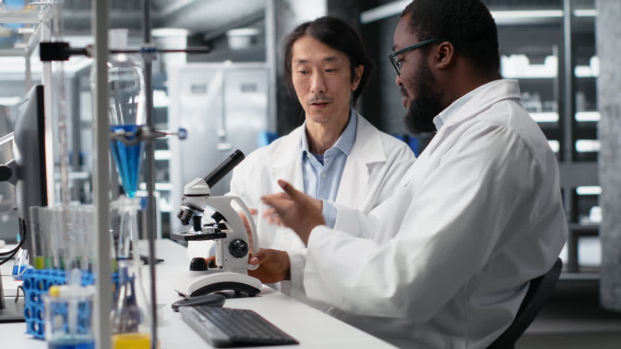 Vertical video Team of multiethnic microbiologists working in lab with molecular microscope