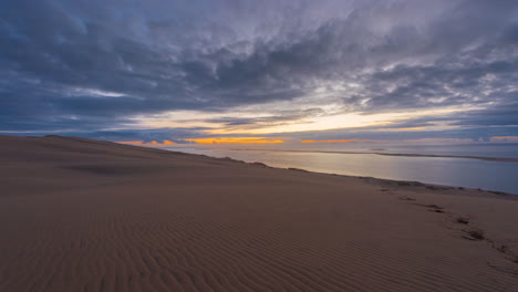 sunset over sand dunes and ocean