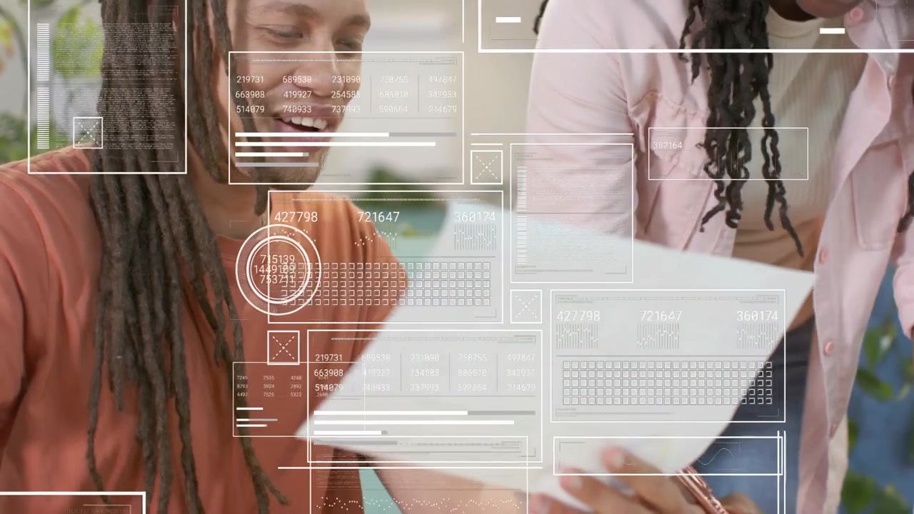 African American coworkers high-fiving while reviewing printed pages with HUD overlays at work desk