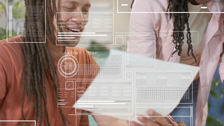 African American coworkers high-fiving while reviewing printed pages with HUD overlays at work desk