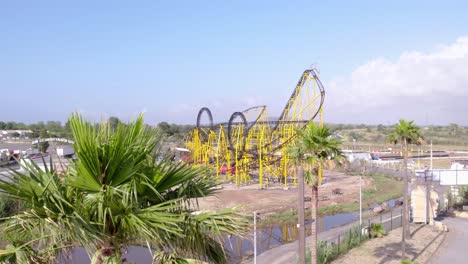 palm trees line the streets with an amusement park featuring roller coasters