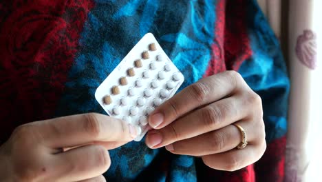 woman holding birth control pills