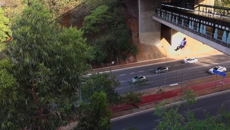 tilt up showing a man rapelling on viaduct and hanging on the rope. extreme sports in the city
