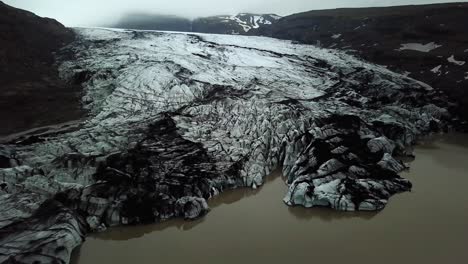 aerial panoramic view of sólheimajökull glacier, melting into water, in summer, iceland