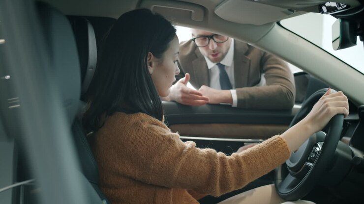 Donna che prova una nuova auto in una concessionaria