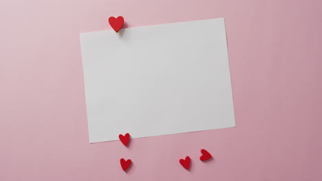 tarjeta blanca con espacio de copia y corazones rojos en fondo rosa en el día de san valentín