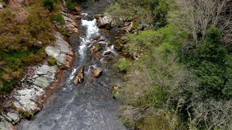 aerial drone shot of sor river while hiking through the viewpoint of aguas caídas, manón, lugo, galicia, spain at daytime