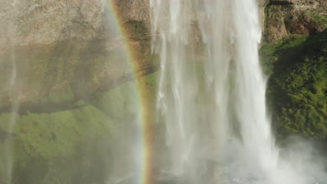flying past stairs at base viewpoint of seljalandsfoss waterfall, rainbow